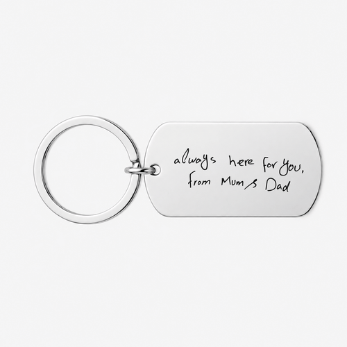 A silver metal keychain with a rectangular tag engraved with the handwritten text 'always here for you, from Mum's Dad' on a light gray background.